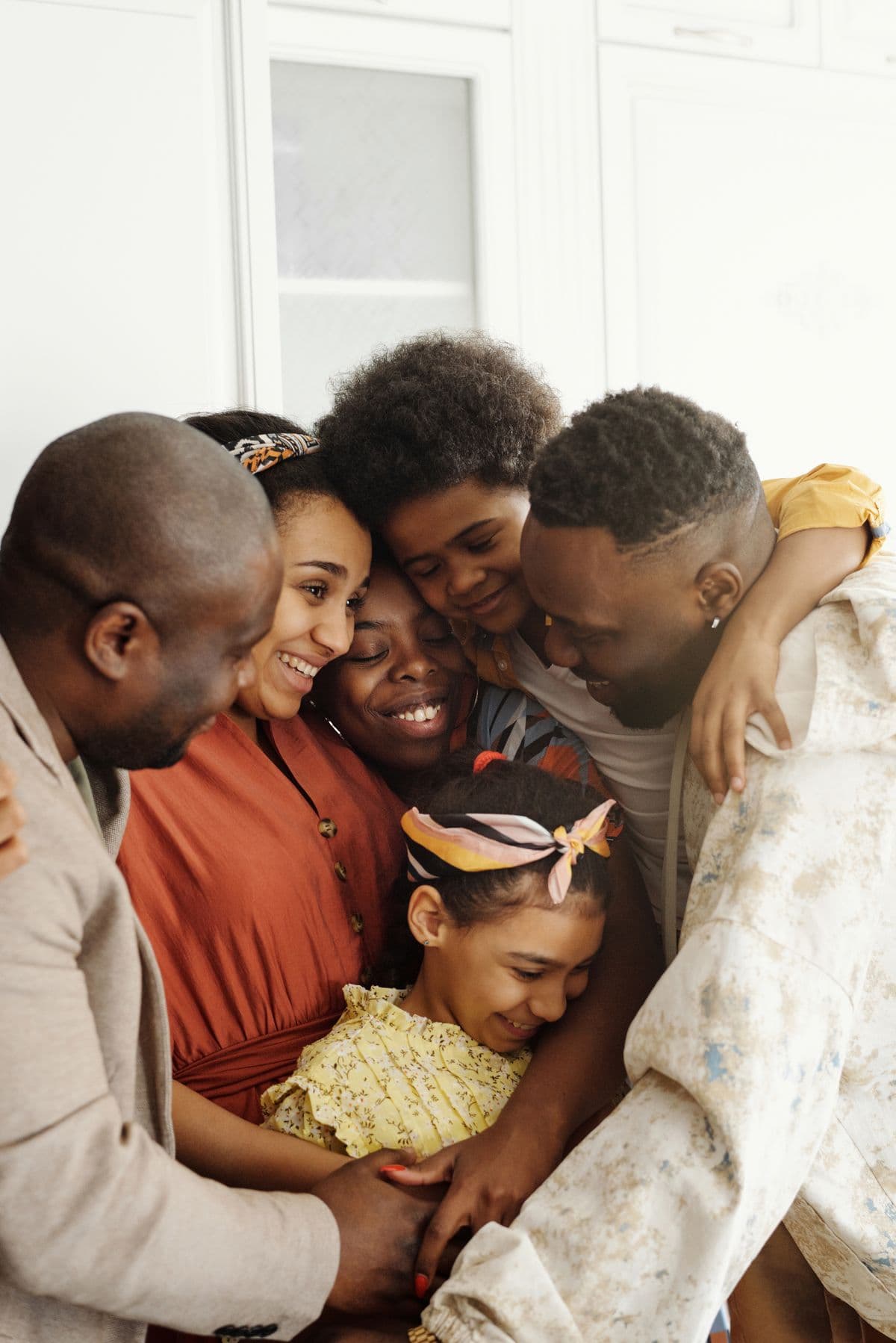 Multi-generational Black family sharing a warm group hug indoors